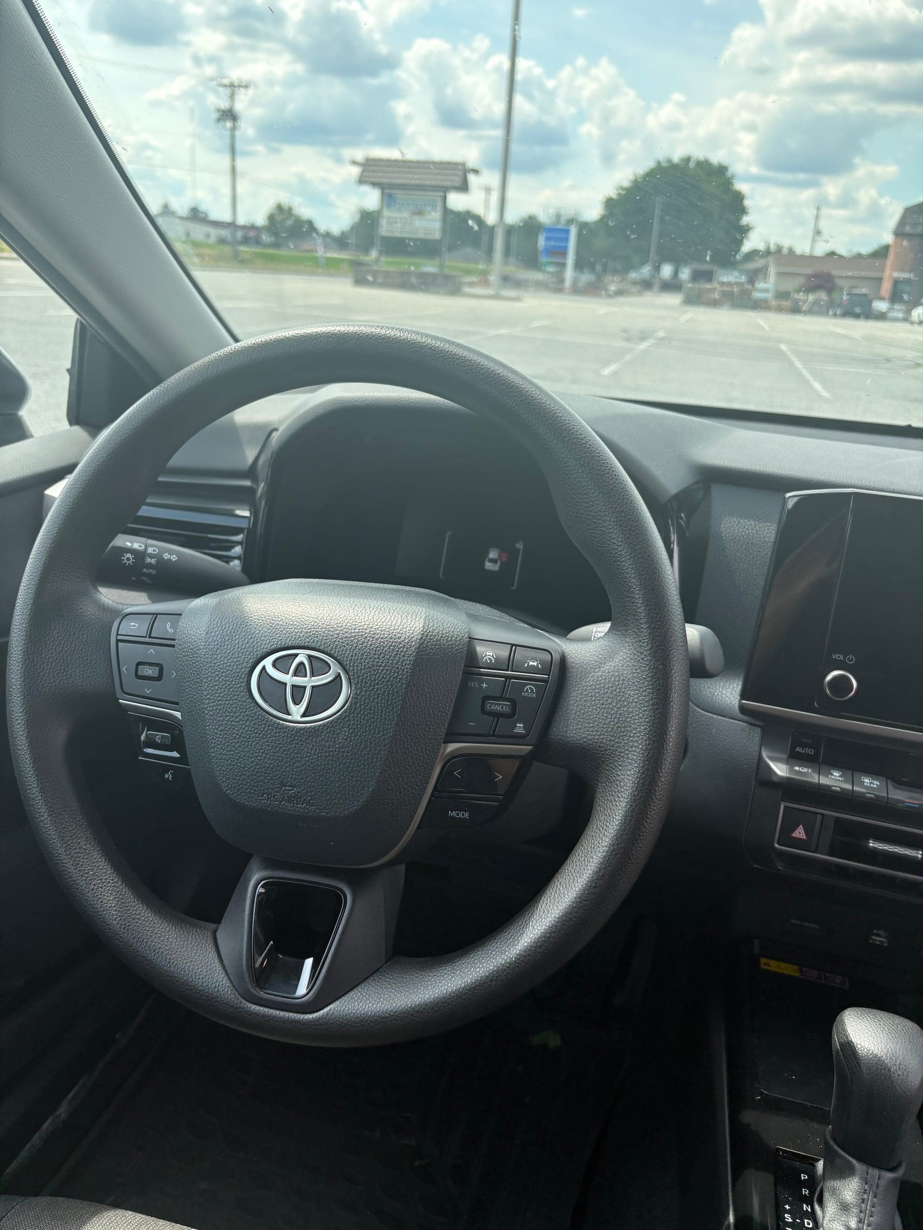 Clean Toyota steering wheel and dashboard with a spotless center console and infotainment screen after detailing