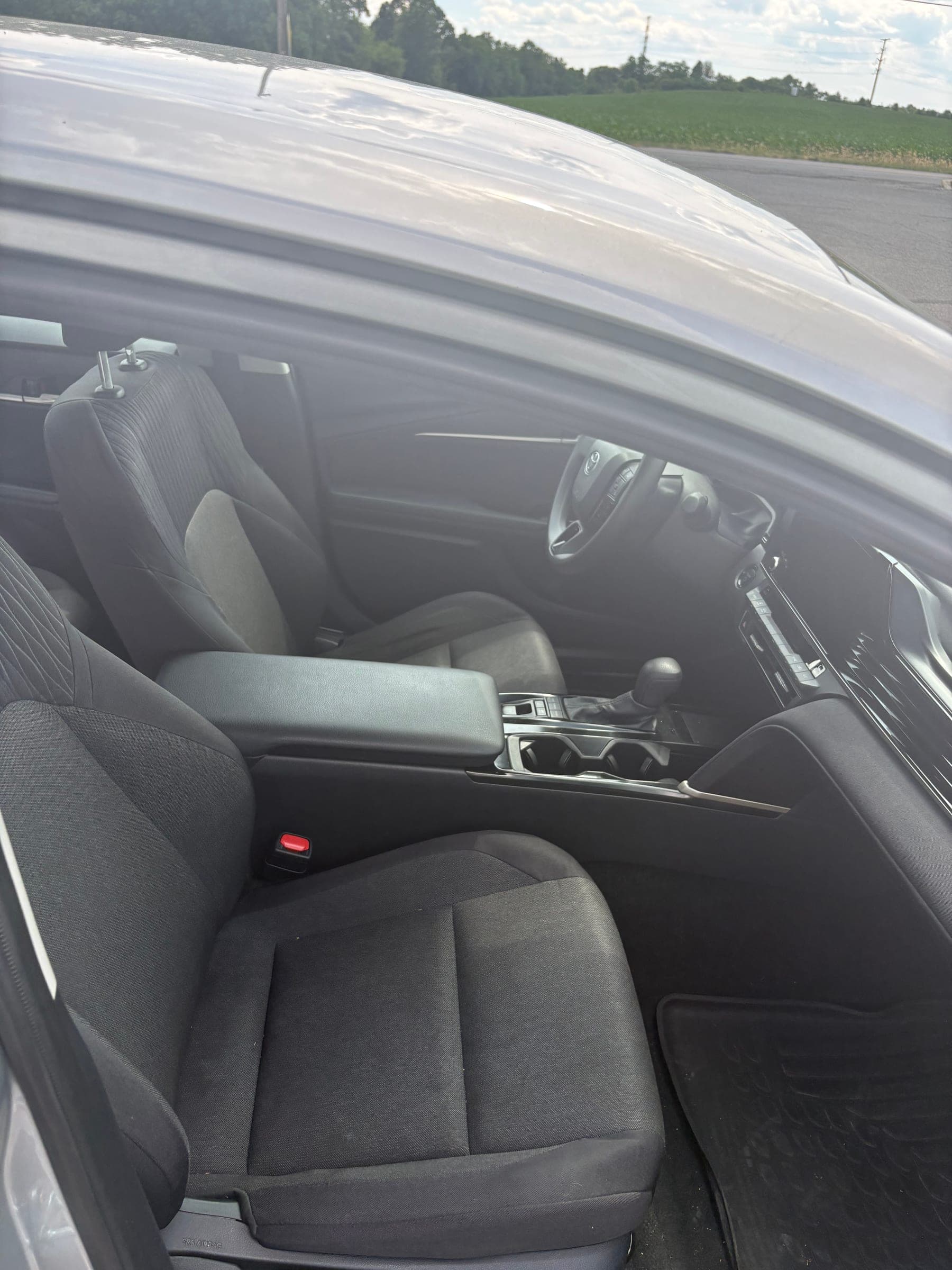 Both freshly cleaned front seats and the center console viewed from the open passenger door