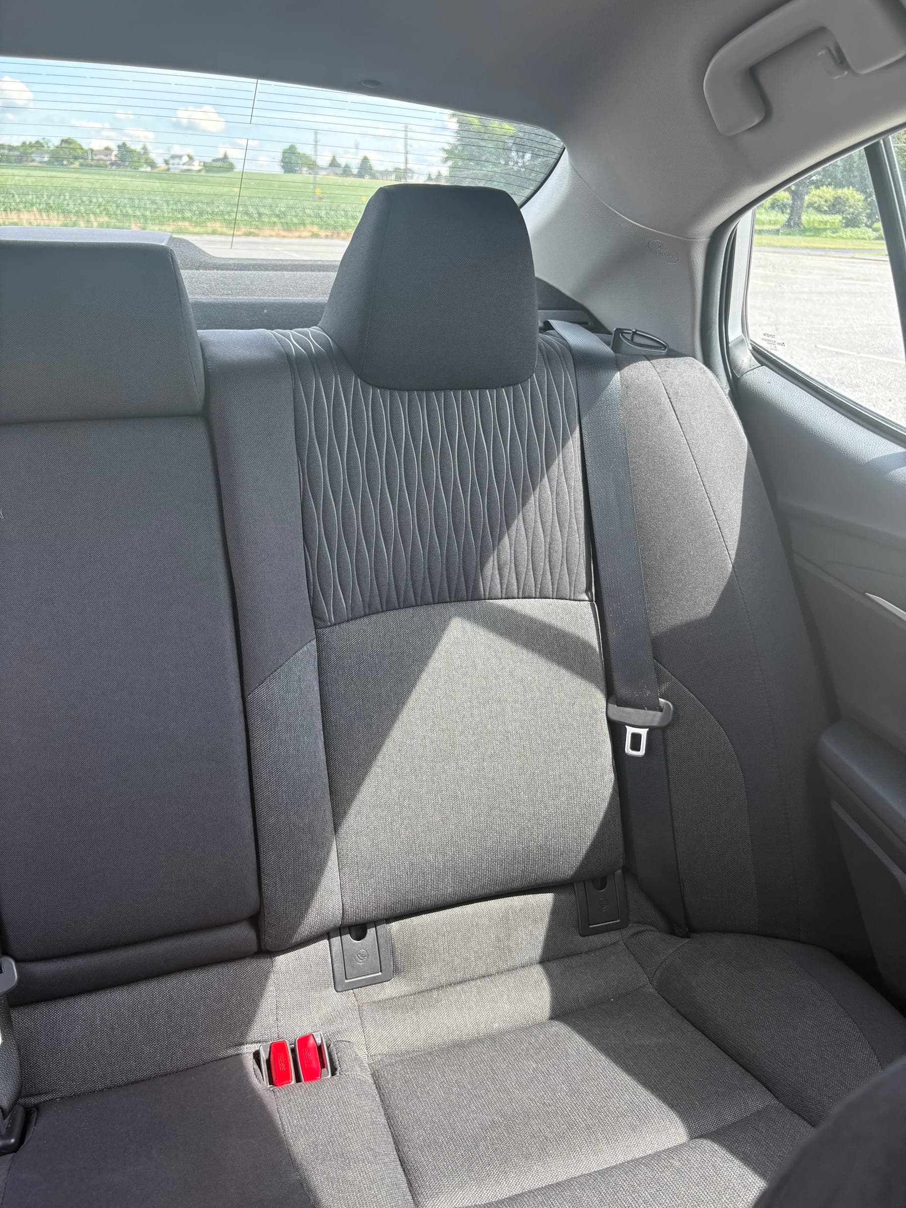 Rear bench seat viewed from the open door, showing clean two-tone quilted upholstery and trim